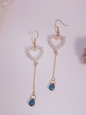Gold-tone dangling earrings with pearl heart and blue crystal