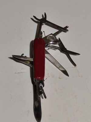 Multitool pocket knife used with red handle and multiple foldable tools