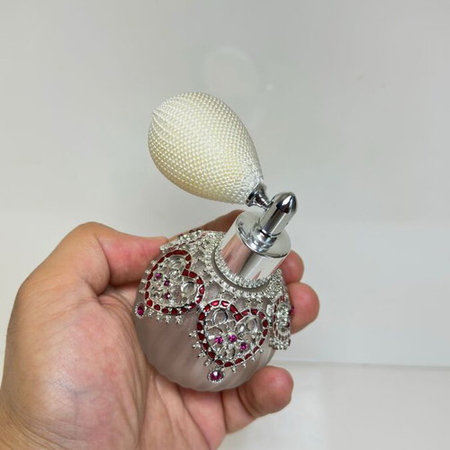 Vintage perfume bottle with pump, decorative hearts and crystals