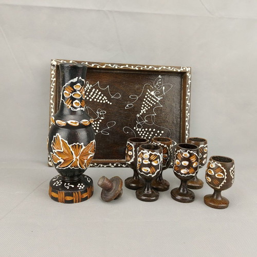 Vintage carved painted wooden bottle with 6 glasses on wooden tray used