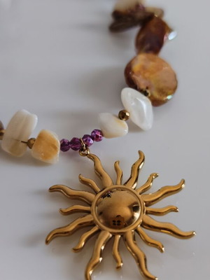Necklace with mother of pearl and gold steel sun pendant