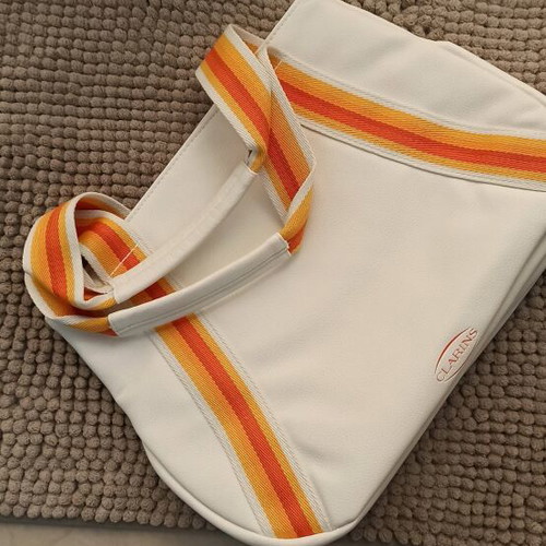 Clarins cosmetic bag new, white with striped handles