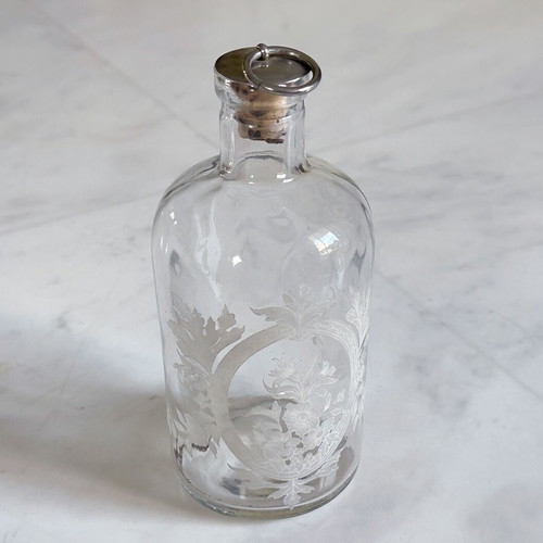 Glass apothecary bottle used with etched floral design