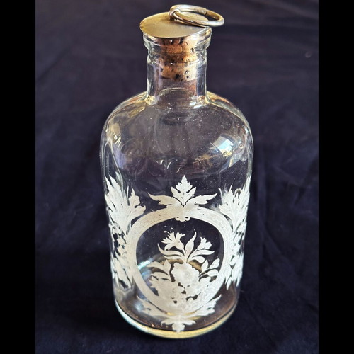 Glass apothecary bottle used with etched floral design