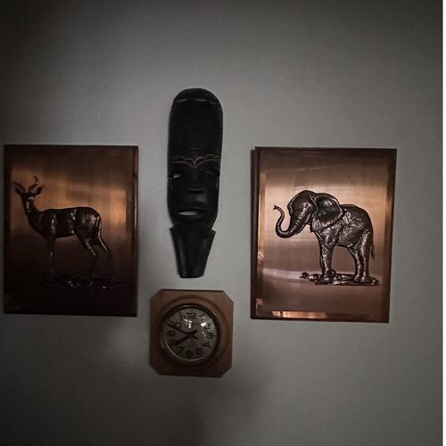 Mask and embossed bronze elephant and antelope wall art