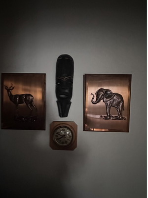 Mask and embossed bronze elephant and antelope wall art