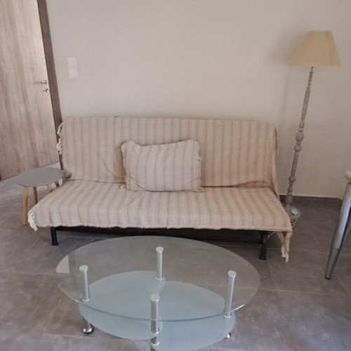 IKEA sofa bed, modern floor lamp, glass coffee table