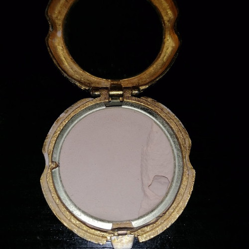 Vintage powder compact used with mirror and gold-plated box with emerald