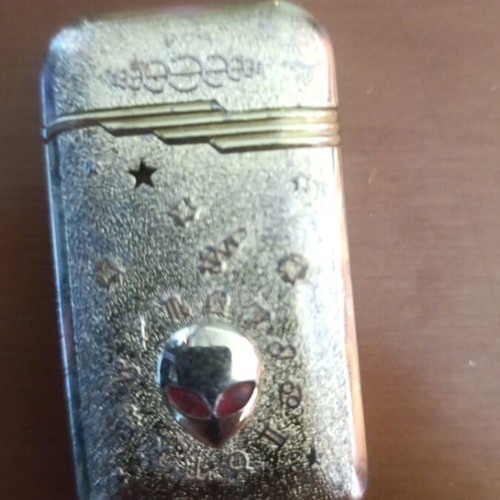 Collectible metal lighter used with zodiac symbols and alien motif
