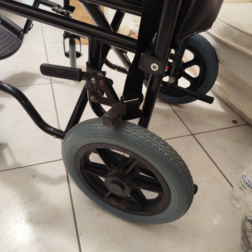 Manual wheelchair used with rear wheel brakes and belt