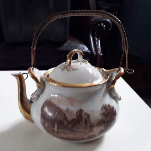 Antique porcelain teapot with wooden handle used
