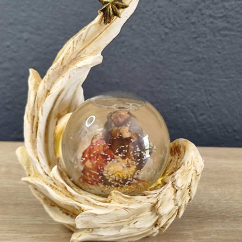 Christmas decorative snow globe featuring the Nativity and a base shaped like an angel's wing