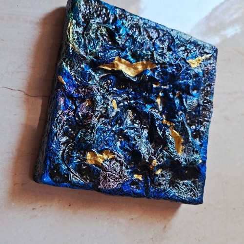 Abstract painting with blue and gold textured surface