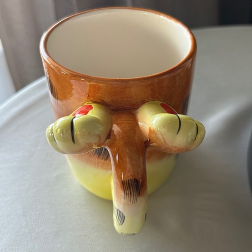 Vintage ceramic mug with embossed monkey design, used