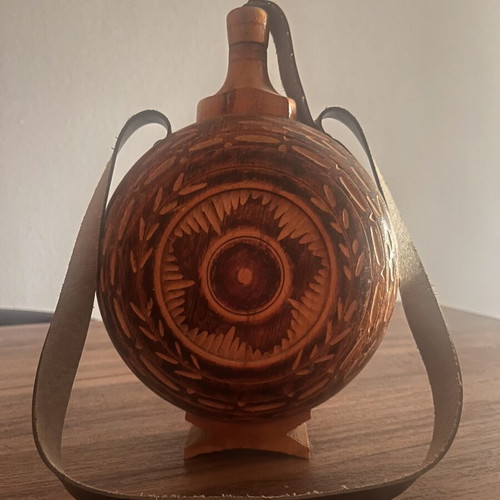 Wooden flask used with carved decoration and leather strap