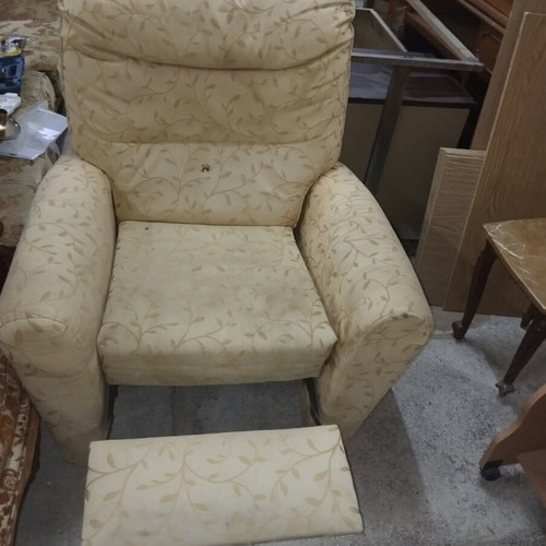 Armchair with footrest and recliner mechanism used, beige with floral pattern