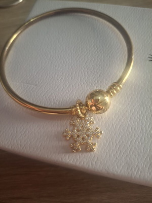 Gold charm snowflake decorated with zircon stones