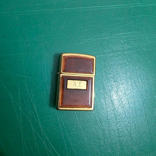 Vintage Zippo lighter in gold with glossy reddish frame