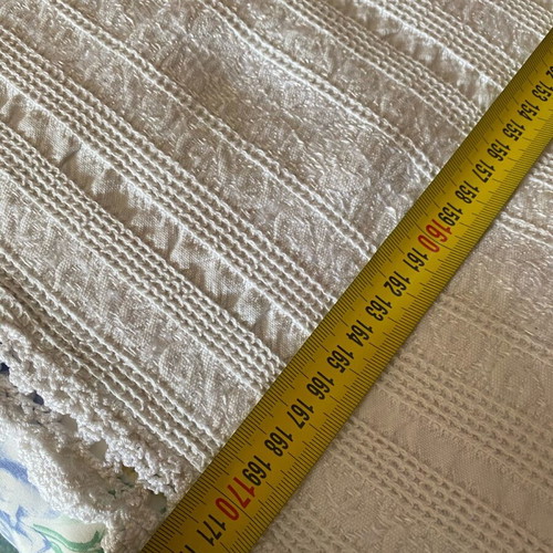 Woven cotton bedspread used with handmade lace trim