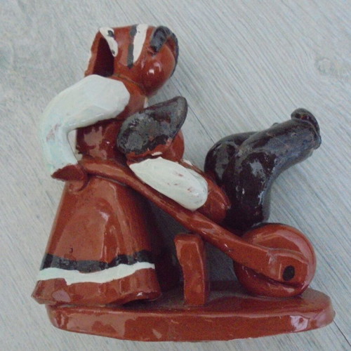 Ceramic figure used, retro genre scene woman pushing man in cart