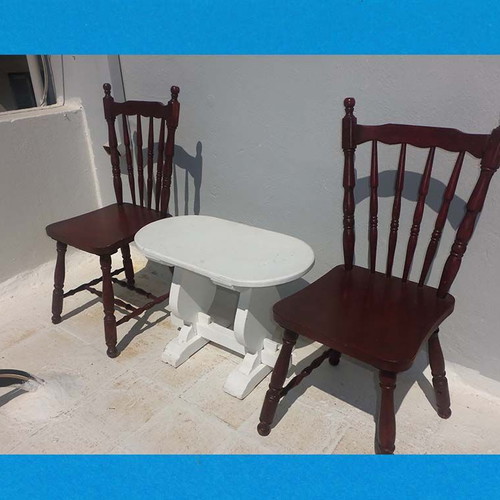 Wooden set with oval white table and 2 traditional dark chairs used for outdoor