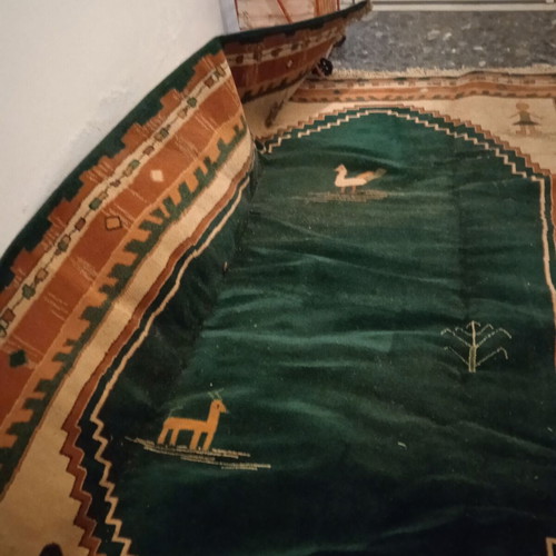 Turquoise machine-made rug used with animal and human designs