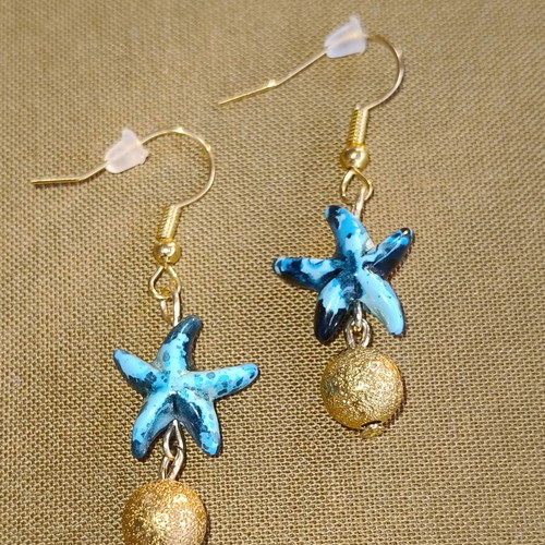 Handmade gold-tone earrings with blue starfish