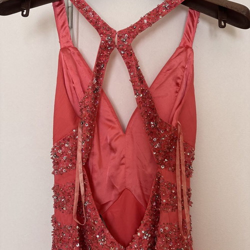 Coral short evening dress with crisscross straps, V neckline, and shiny embroidered beads