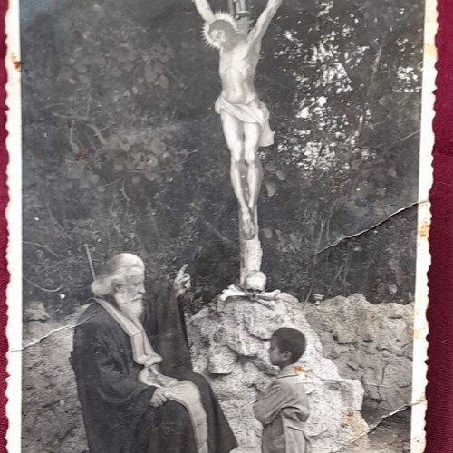 Vintage photo used Orthodox priest and child praying before crucifix