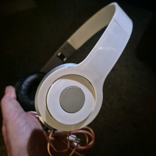 Foldable on-ear headphones used, white with silver details