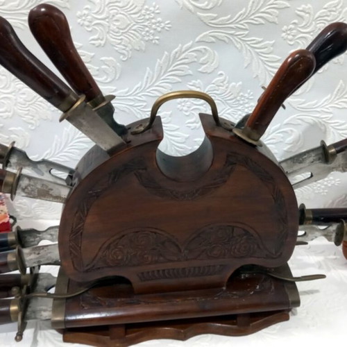 Wooden carved stand with used set of knives and forks