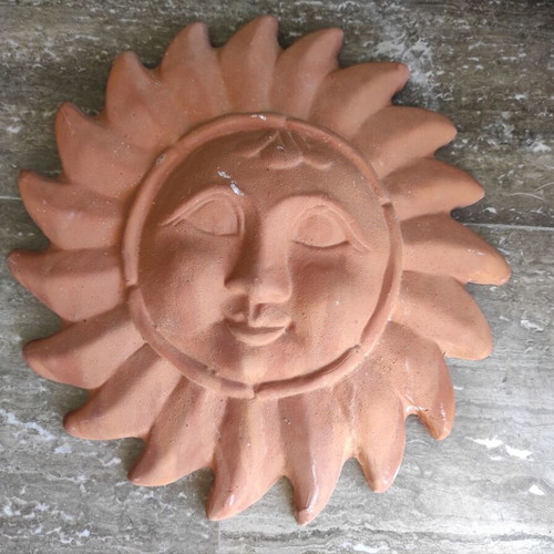 Clay wall decorative depicting the Sun in human form