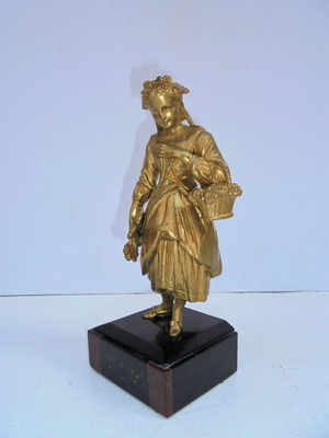 Metal statue of a girl antique with traditional French costume