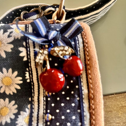 Accessorize vintage crossbody bag with daisies and cherries