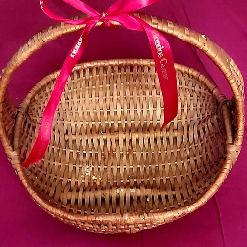 Woven straw basket used with red satin ribbon