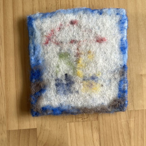 Handmade wool wall art with children under umbrella
