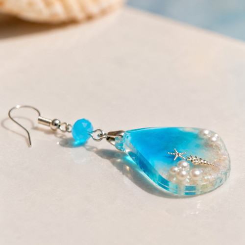 Handmade earrings with stars, shells, pearls, and crystals in resin