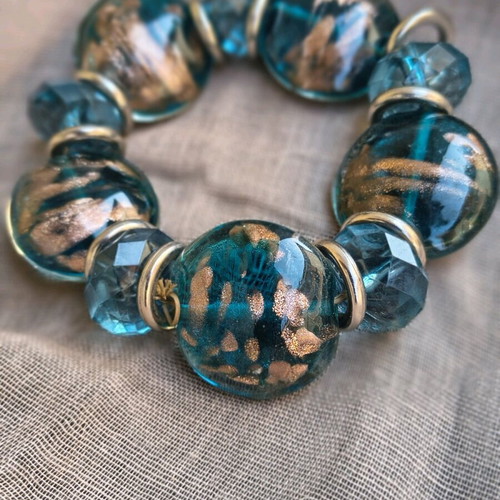 Elastic bracelet like new with petrol glass beads and gold details