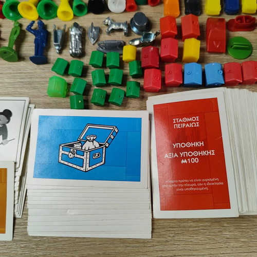 Lot of used board game parts including pawns, dice, cards, and hourglasses