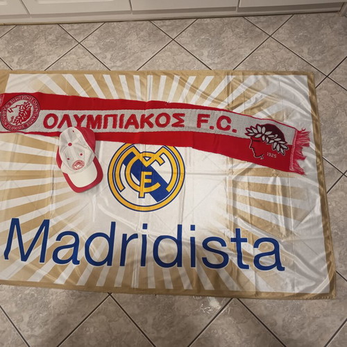 Real Madrid and Olympiakos accessories used with flag, scarf, and cap