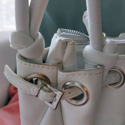 White bucket handbag used with decorative buttons