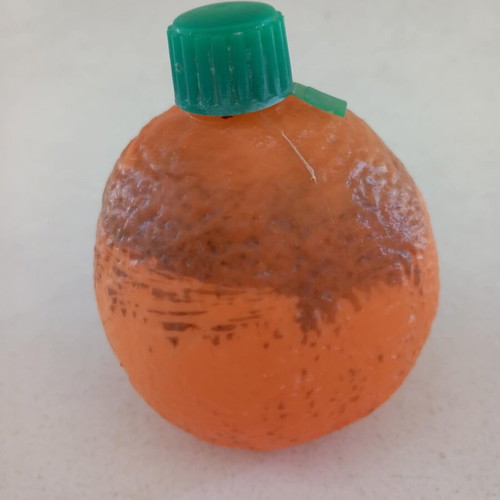 Plastic orange-shaped bottle used for beverage