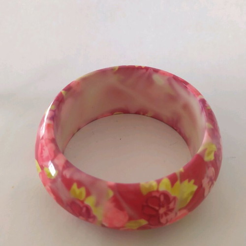 Bracelet asymmetric with pink flowers and green leaves on red background