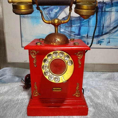 Vintage metal rotary phone, red with gold details
