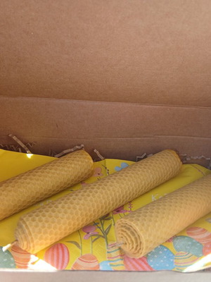 Handmade beeswax candles in decorative box with herbs and oils
