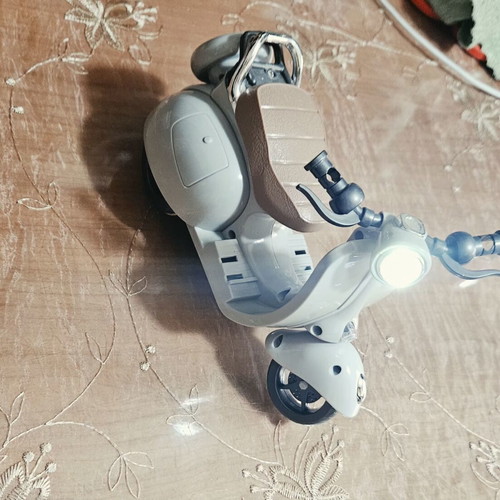 Toy motorcycle for dolls, plays music and moves