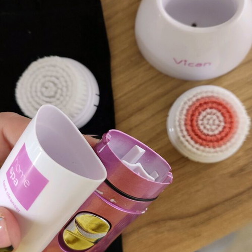 Facial cleansing device used with two heads and stand