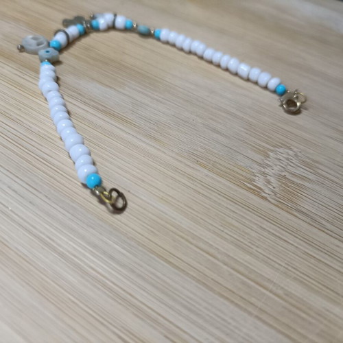 Bracelet with blue and white beads, peace sign and charms