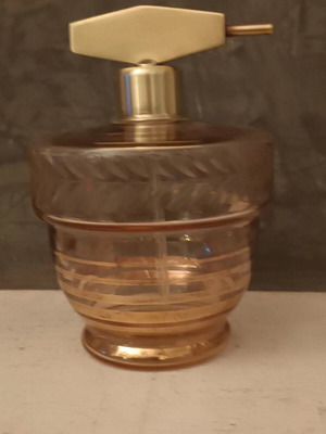 Vintage perfume bottle used with pink tint and brass spray