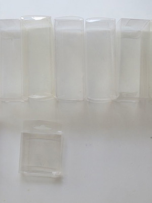 Plastic transparent cases used for figures and Game Boy